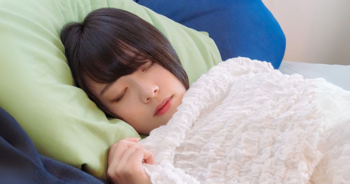 布団で横になり安らかに眠る女性