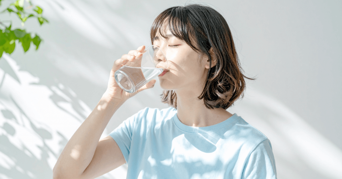 水を飲んで口の中を清潔に保つ女性