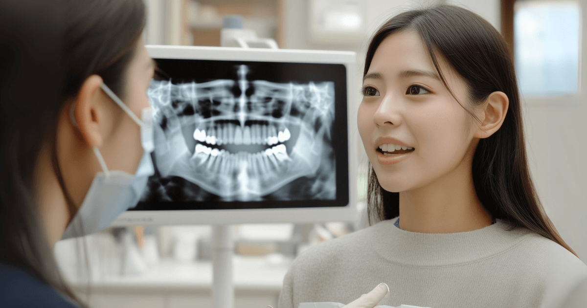 歯科医院でレントゲンを見ながら相談する女性患者