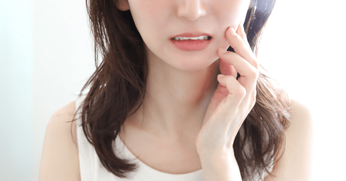 歯を噛むと痛みを感じる女性の写真