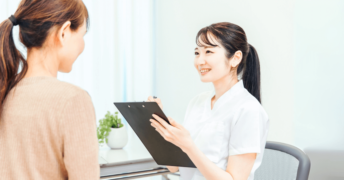 歯科スタッフと笑顔で相談する患者