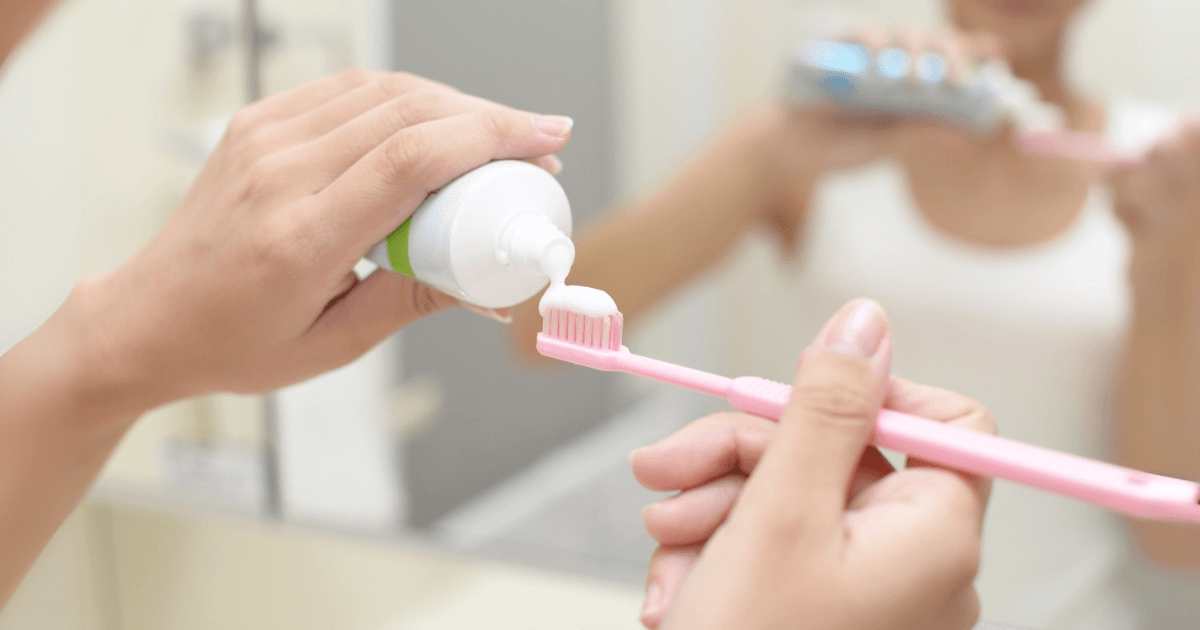 歯ブラシに歯磨き粉をのせて再石灰化ケアを準備する様子