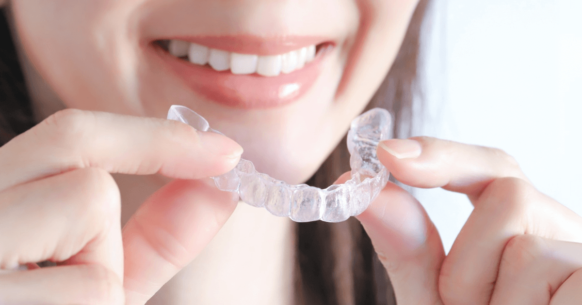 歯ぎしり対策のためマウスピースを持つ女性の笑顔
