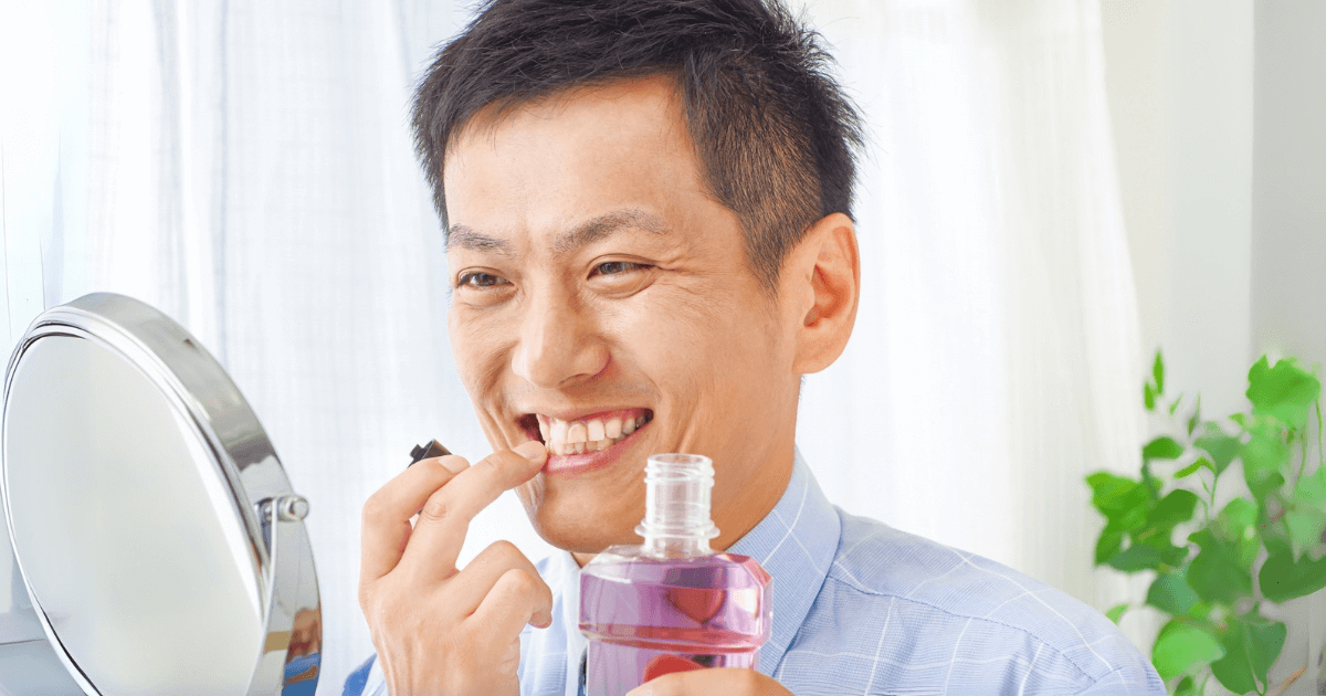 洗口液で歯や歯茎のケアをする男性
