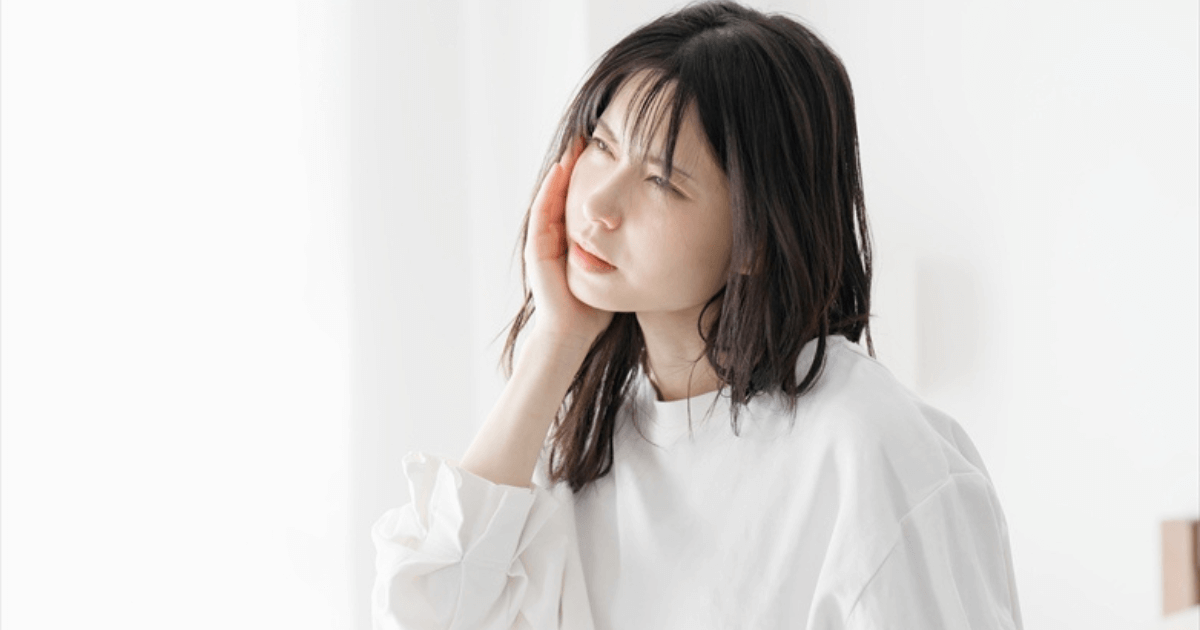 歯の痛みで頬を押さえて苦しむ女性