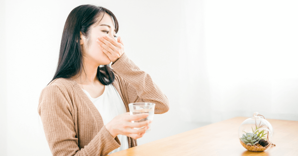 歯の痛みで頬を押さえている女性