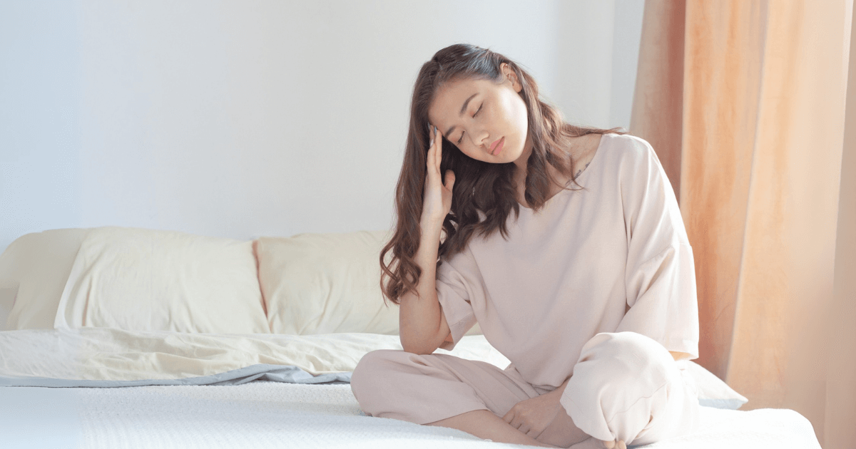ベッドで眠れず悩んでいる女性