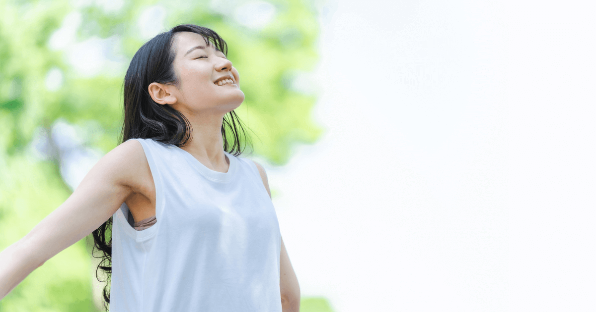 自然の中で笑顔でリラックスする女性