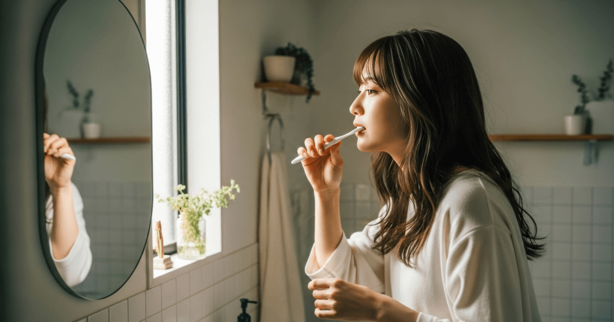 鏡を見ながら歯を磨く女性
