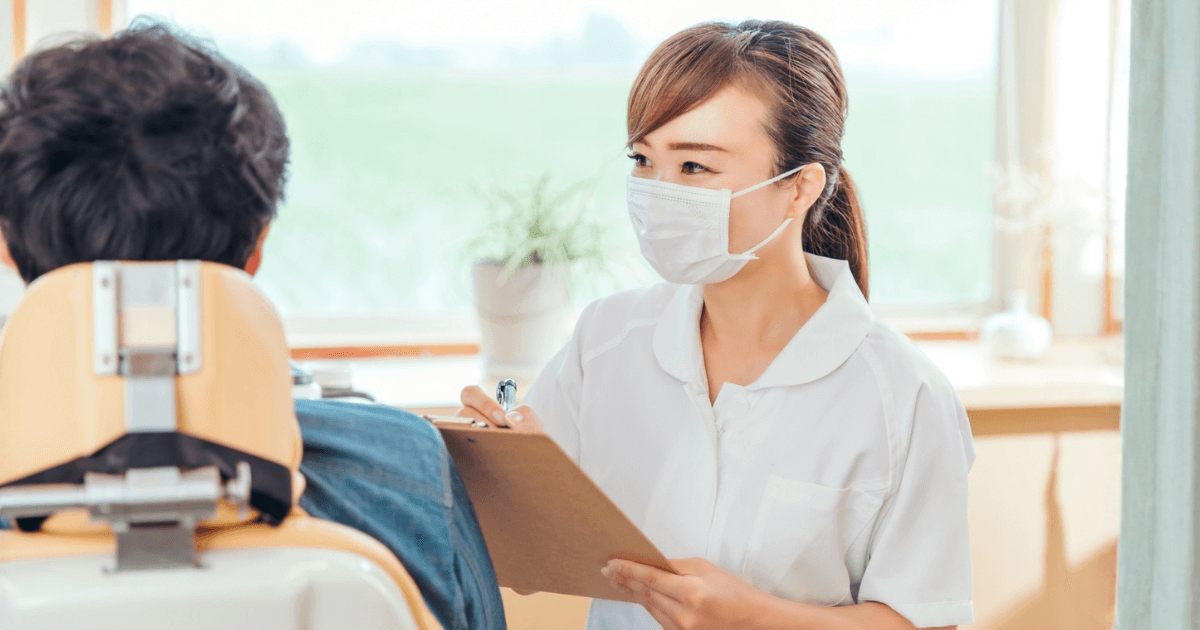 歯科医院で治療の説明を受ける患者と歯科衛生士