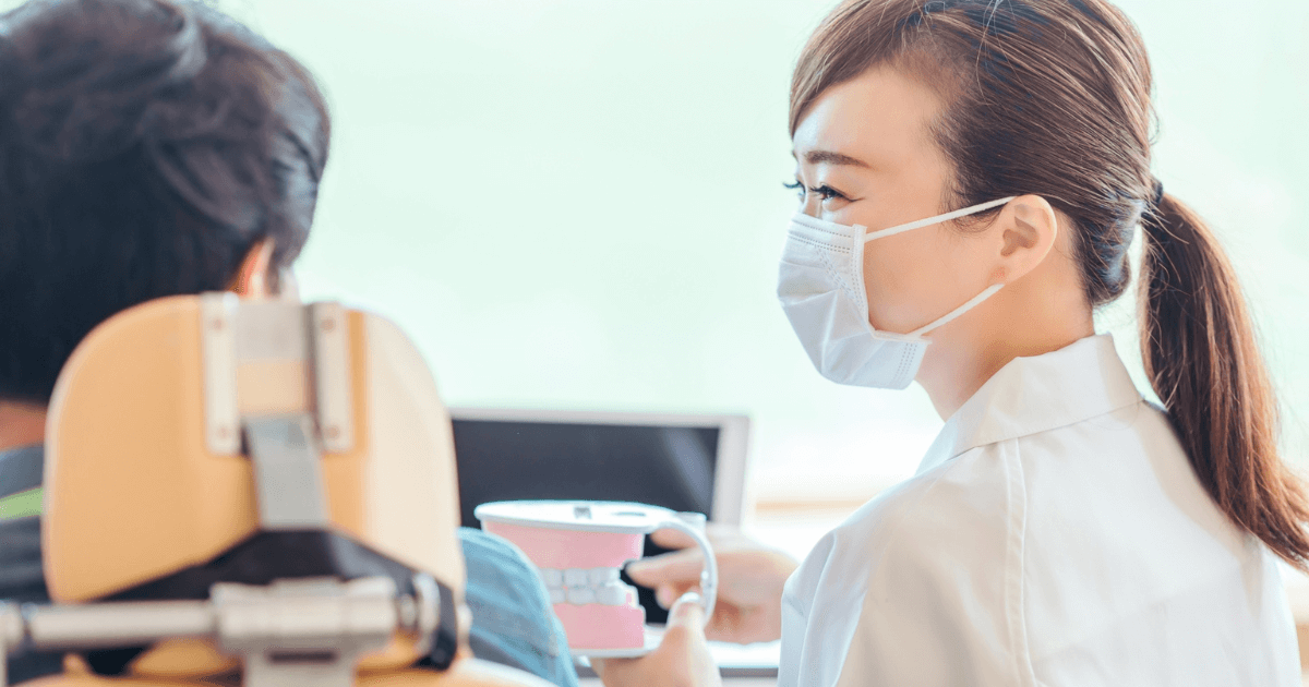 歯科医院で模型を使いながらケア方法を説明する歯科医