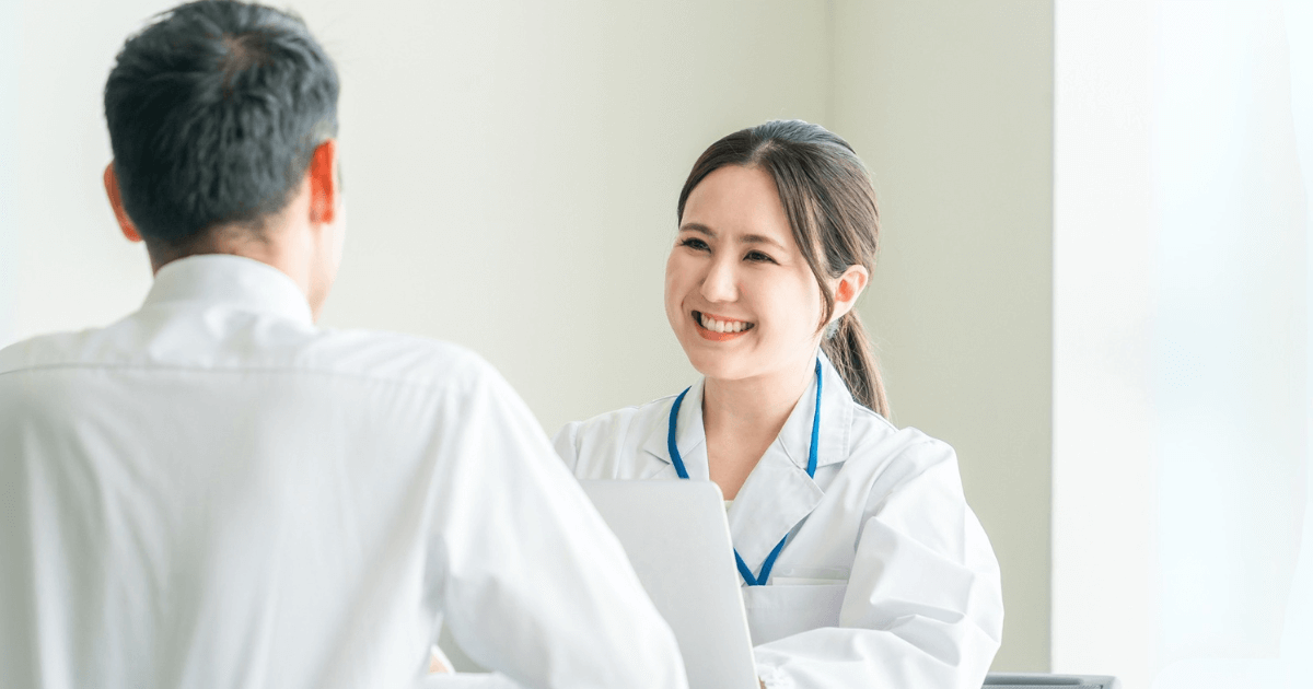 笑顔で患者と話す歯科医のカウンセリング風景