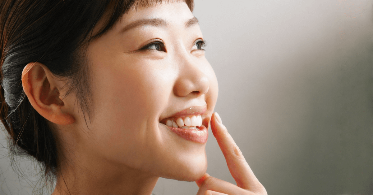 歯の痛みが改善し、笑顔を見せる女性。ストレスケアと早めの歯科受診で健康な歯を保つイメージ。