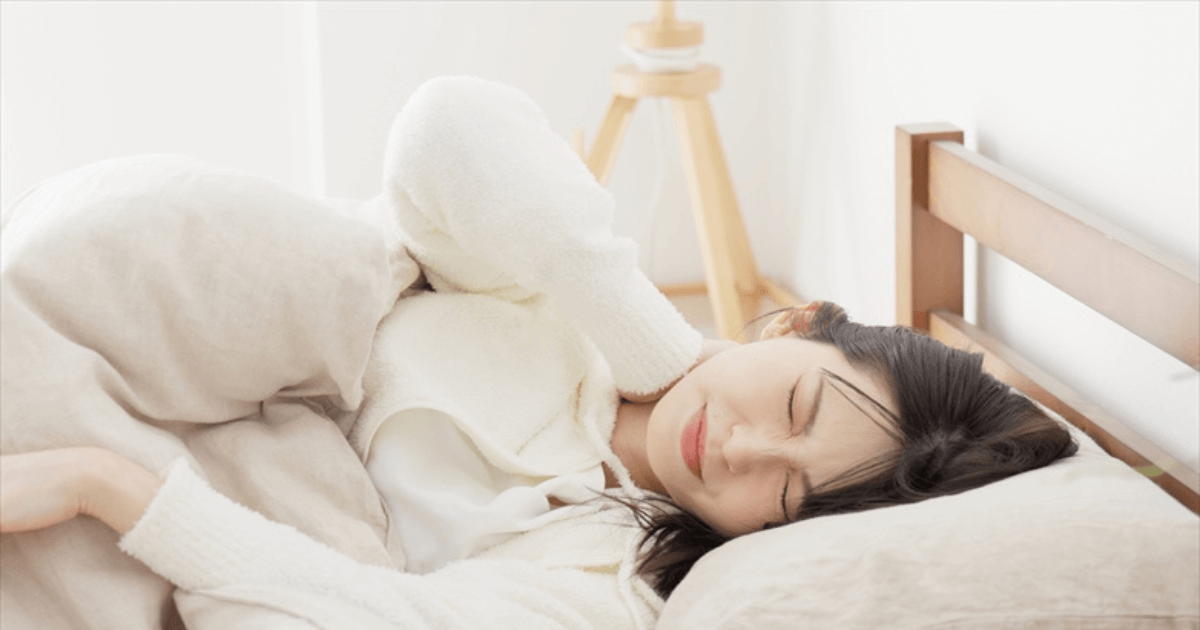 夜になると歯が痛み、寝つけずに悩む女性のイメージ。血流やストレス、歯ぎしりが関係する様子。