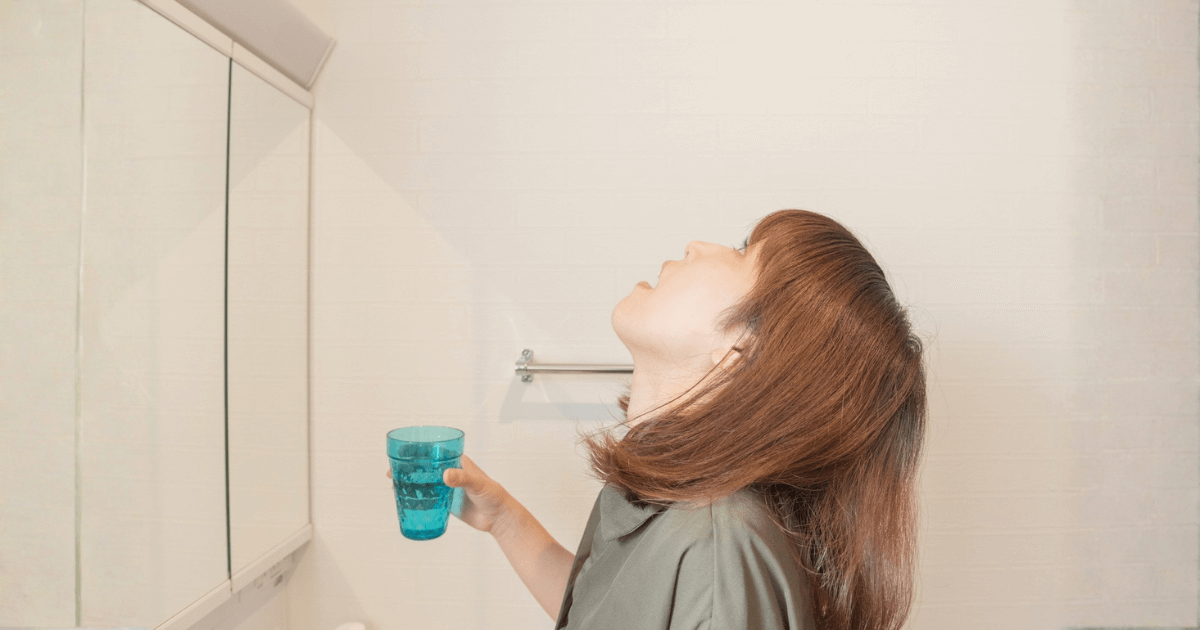 歯の痛みをやわらげるためにうがいをしている女性のイメージ
