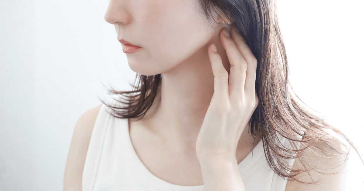 顎に手を添えて痛みを気にしている女性の横顔