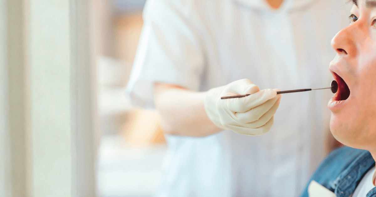 親知らずの抜歯後に口が開きにくい状態で、歯科医院で抜糸や口腔内の確認を受けている様子