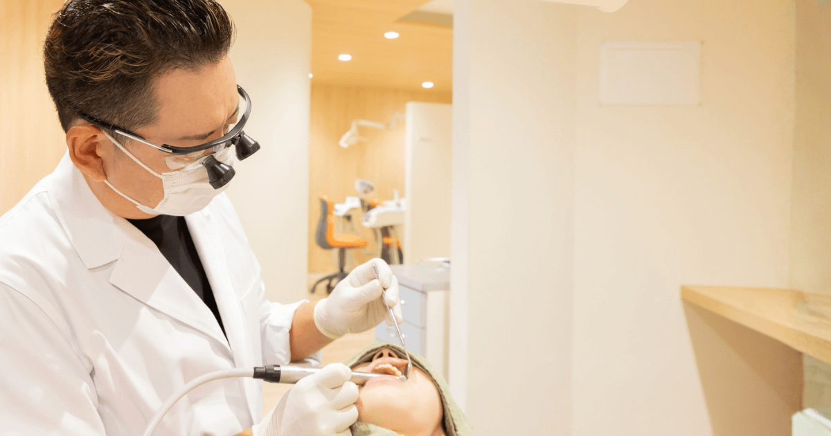 神経を保護する薬の治療後に痛みが続き歯科医師と次の治療を相談している様子