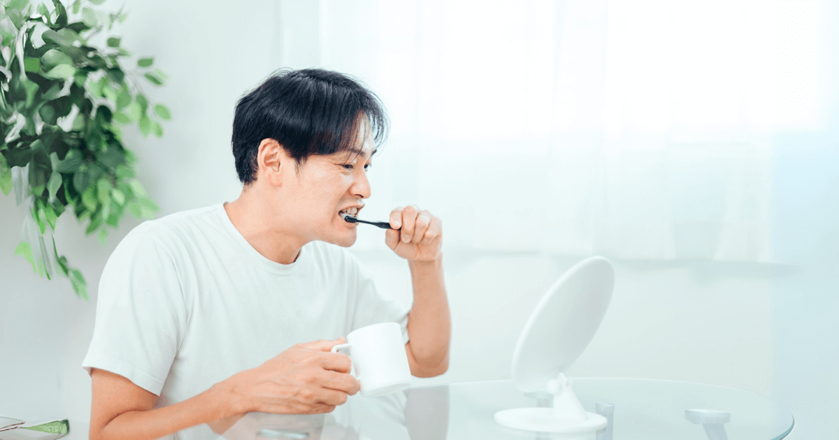 鏡を見ながら歯を丁寧に磨く男性