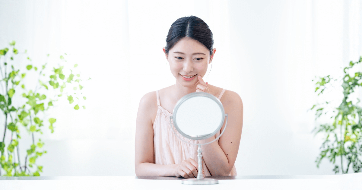 鏡で口の中を優しく確認している女性のイメージ