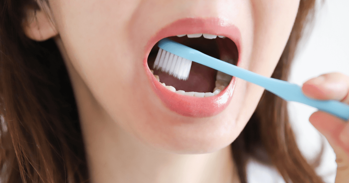 奥歯を丁寧に磨いてケアしている女性の口元の写真