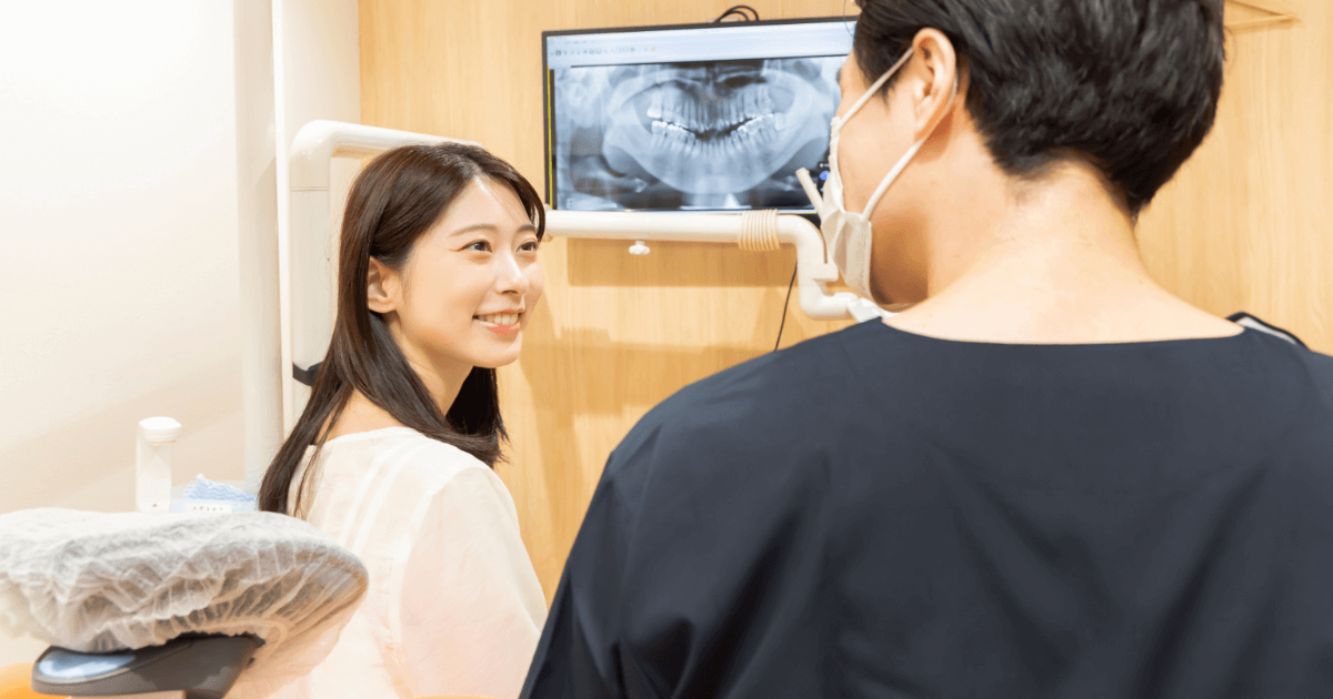 抜歯後の不安について歯科医師に相談し、安心して説明を受ける女性のイメージ