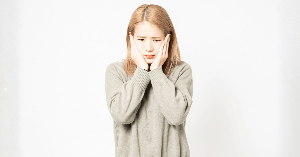 親知らずの抜歯後に口が開きにくく、痛みや違和感が続いて歯科への相談を検討している女性の様子