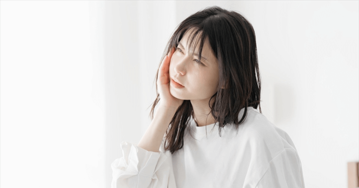 奥歯の痛みに悩み抜歯するべきか迷っている女性